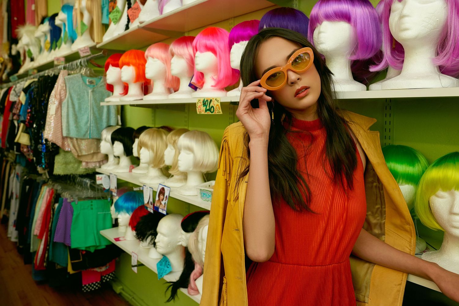 Stylish scene in wig shop with colorful display of hairpieces on mannequin heads.