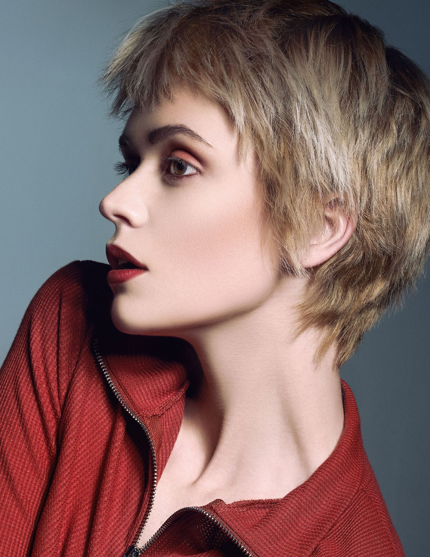 Profile shots of a person wearing a red turtleneck sweater against a gray background.