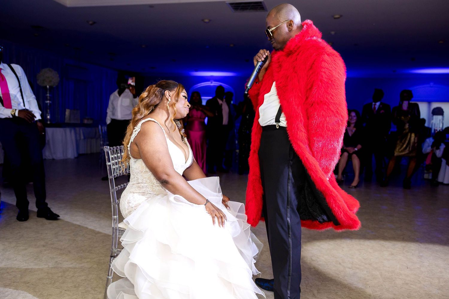 A wedding couple shares a special dance moment on the dance floor with the groom wearing a dramatic red cape.