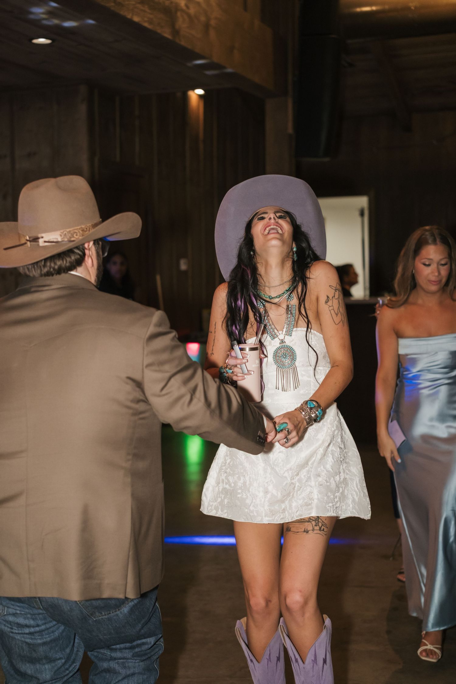 People dancing and celebrating at what appears to be a party or celebration in a dimly lit indoor space.