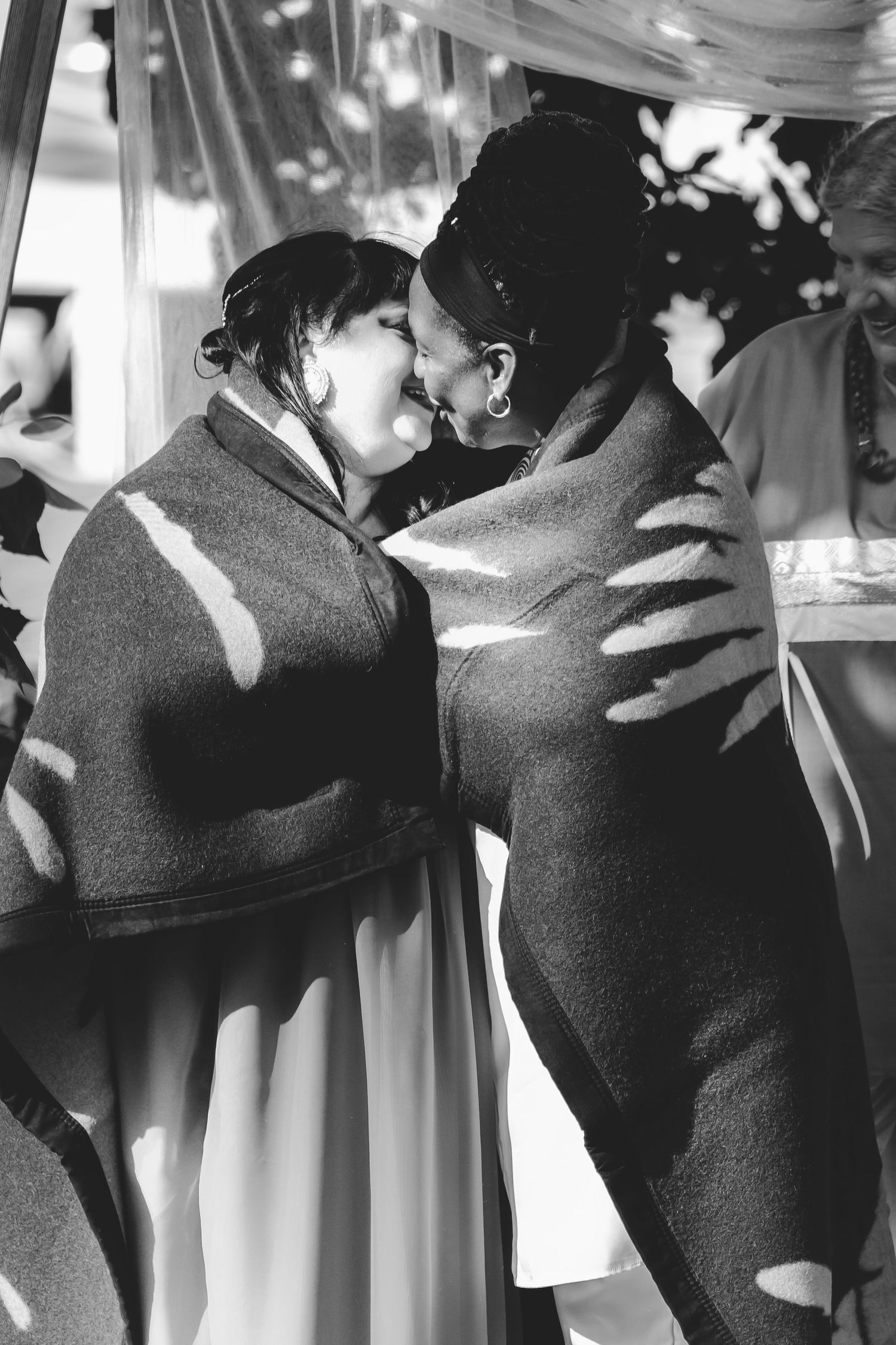 Black and white intimate moment between two people at a wedding celebration.