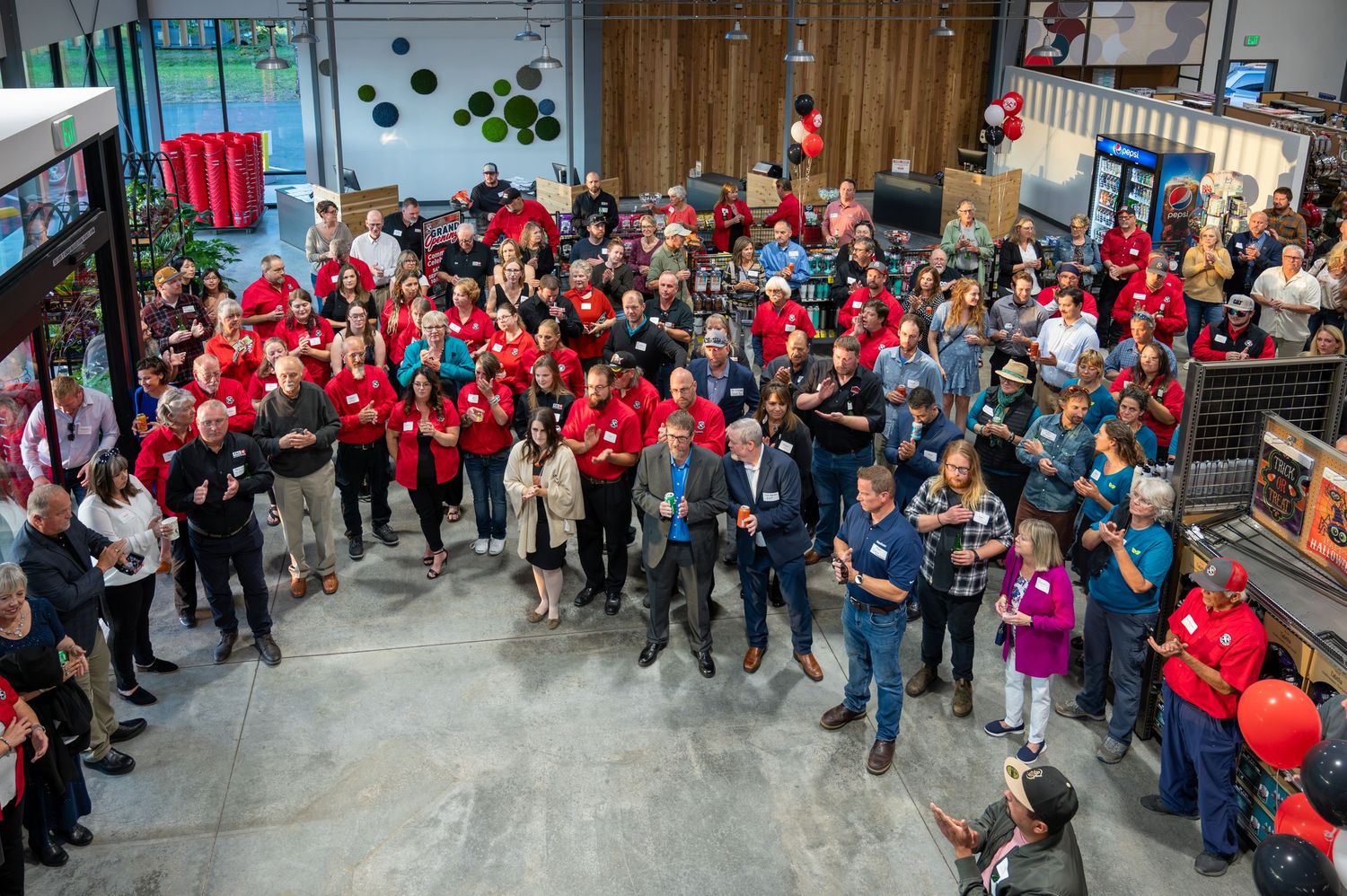 Overhead view of crowd wearing red uniforms gathered in industrial space with concrete floors.