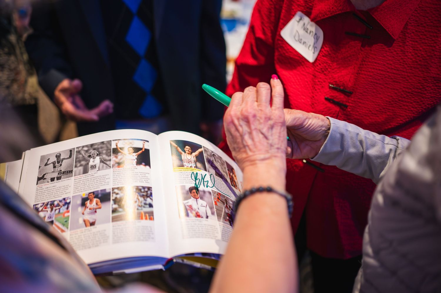 Person looking through photo album or memory book at an event.