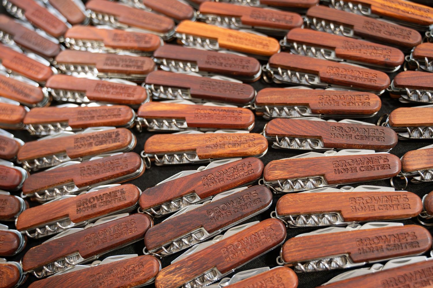 Rows of identical brown wooden corkscrews arranged in a geometric pattern.