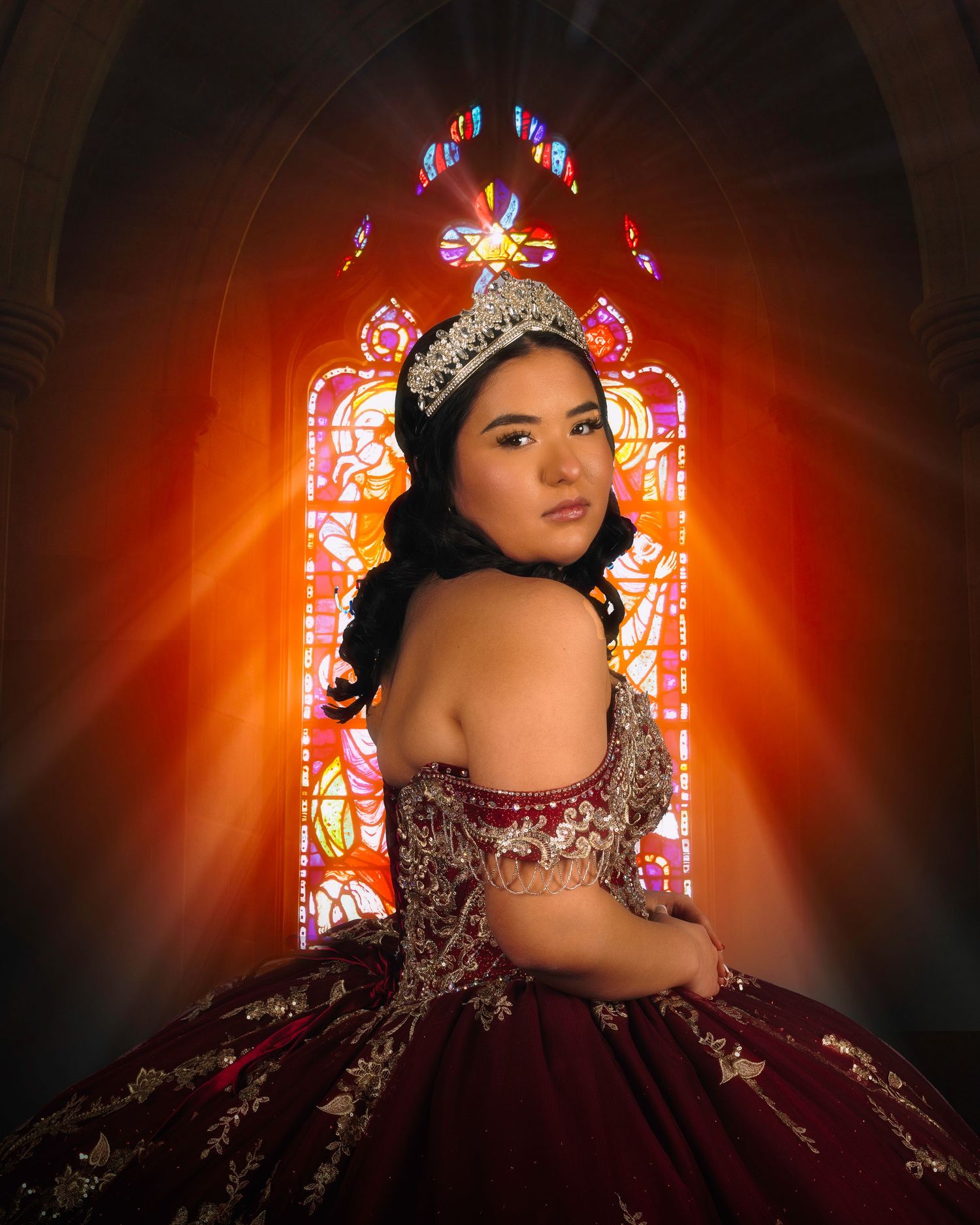 Elegant portrait with ornate crown against colorful stained glass in a church setting.