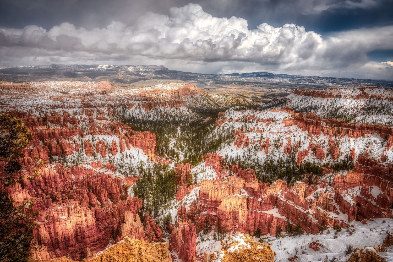 Panoramic winter vista of Bryce Canyon's red rock hoodoos partially covered in fresh snow.