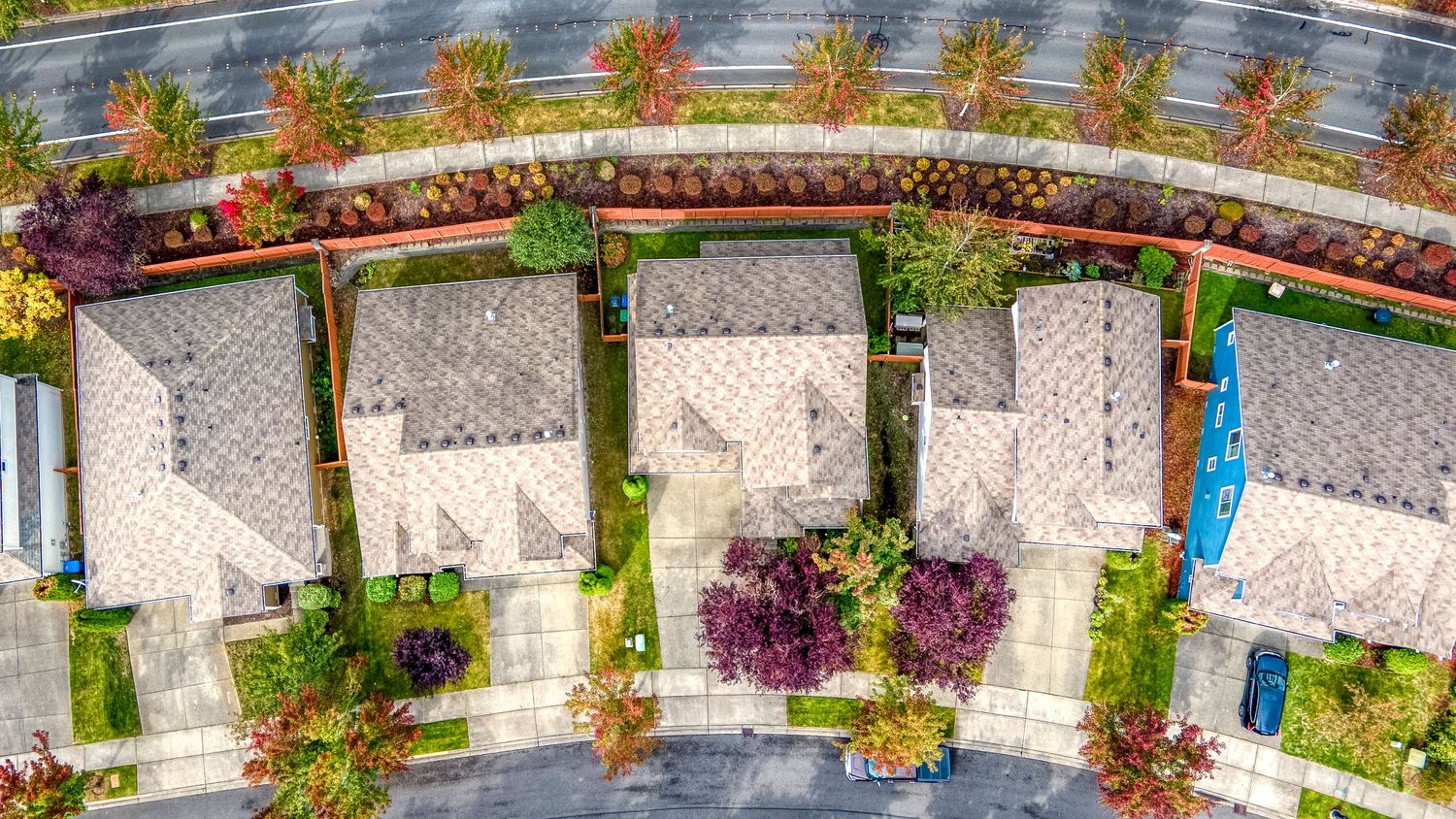 Aerial view of row houses with rooftop gardens and geometric patterns from above.