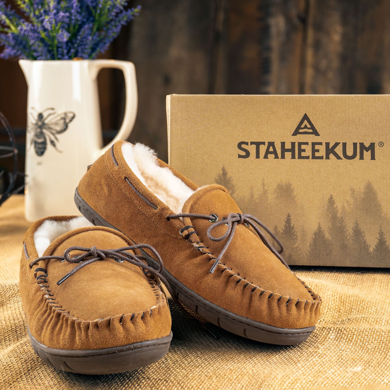 Brown leather moccasins with fur lining displayed with Staheekum box and butterfly print mug.