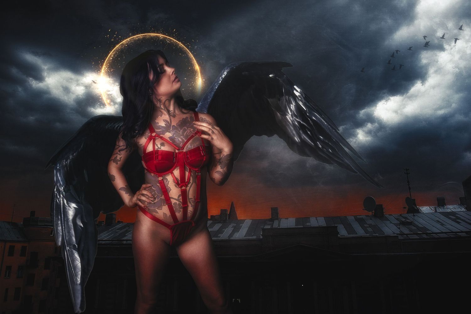 Dramatic dark angel themed photoshoot against stormy urban backdrop with red lingerie.