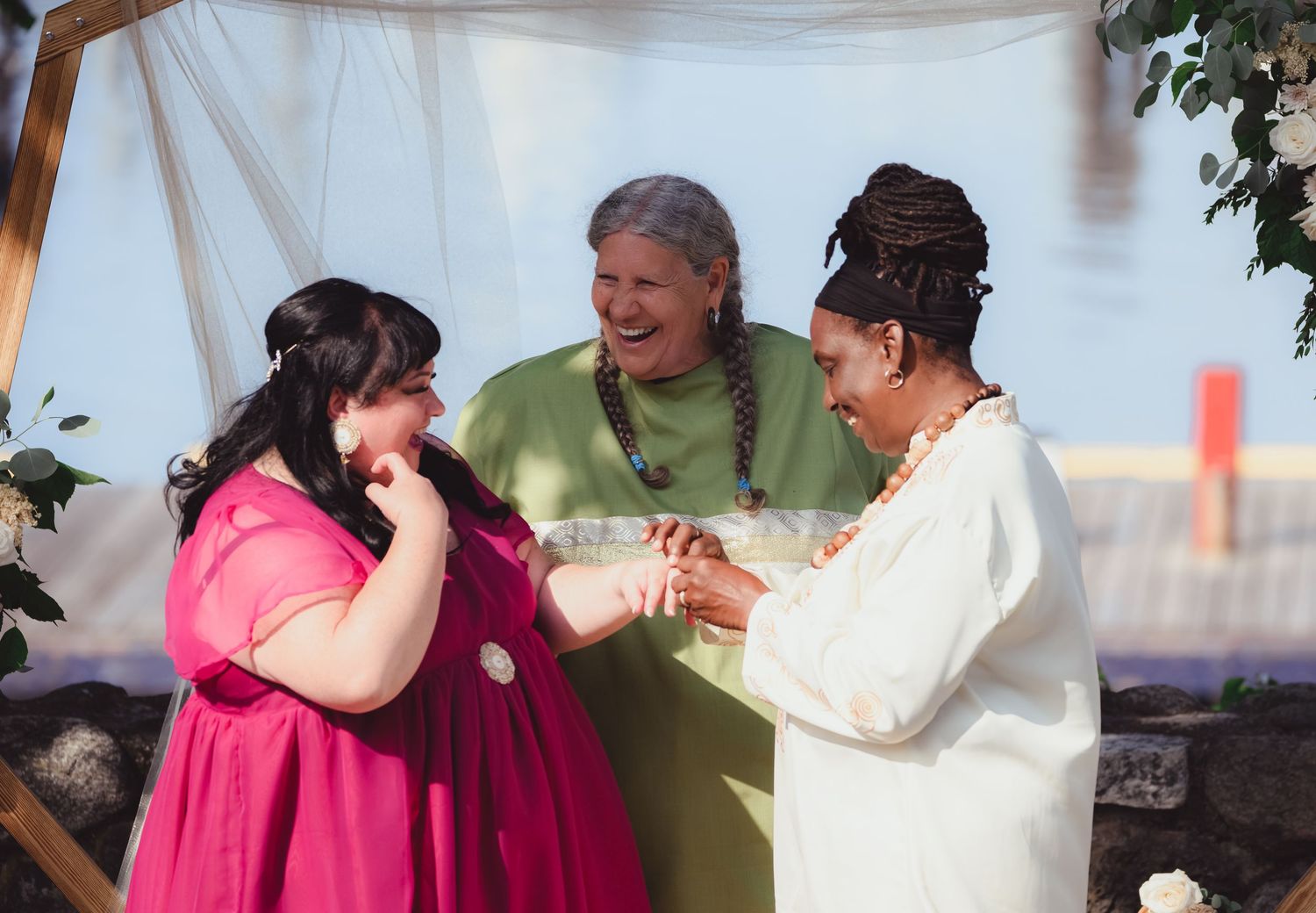 Emotional moment shared between three people at an outdoor wedding ceremony.