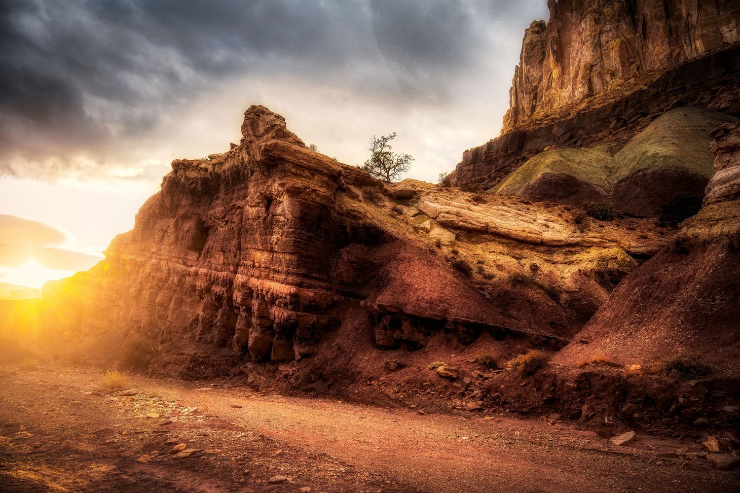 Desert rock formation glowing at sunset with dramatic layered sandstone cliffs.
