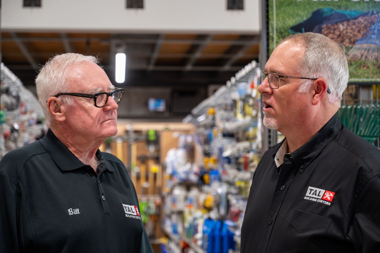 Two retail employees having discussion in store merchandise area.