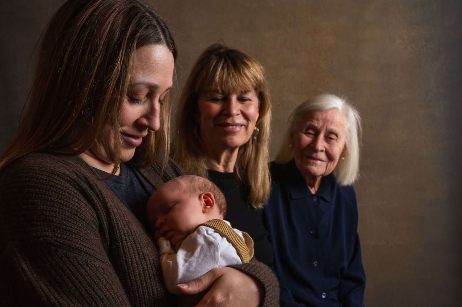 Three generations sharing an intimate moment with a newborn baby.