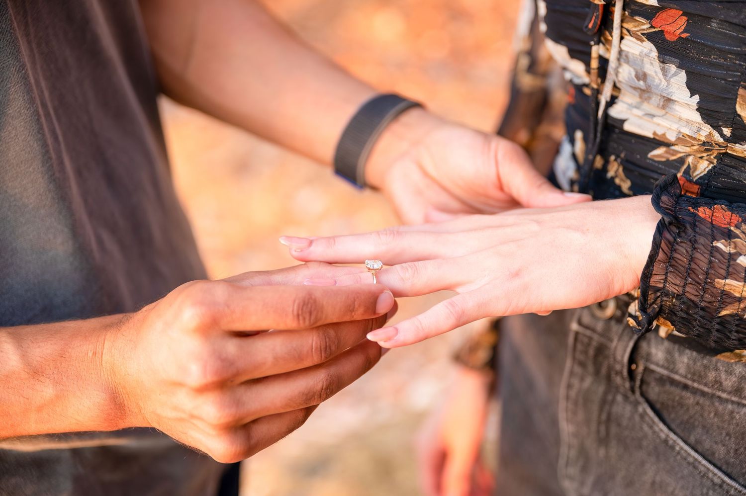 Close-up shot of hands during a romantic proposal moment with ring exchange.