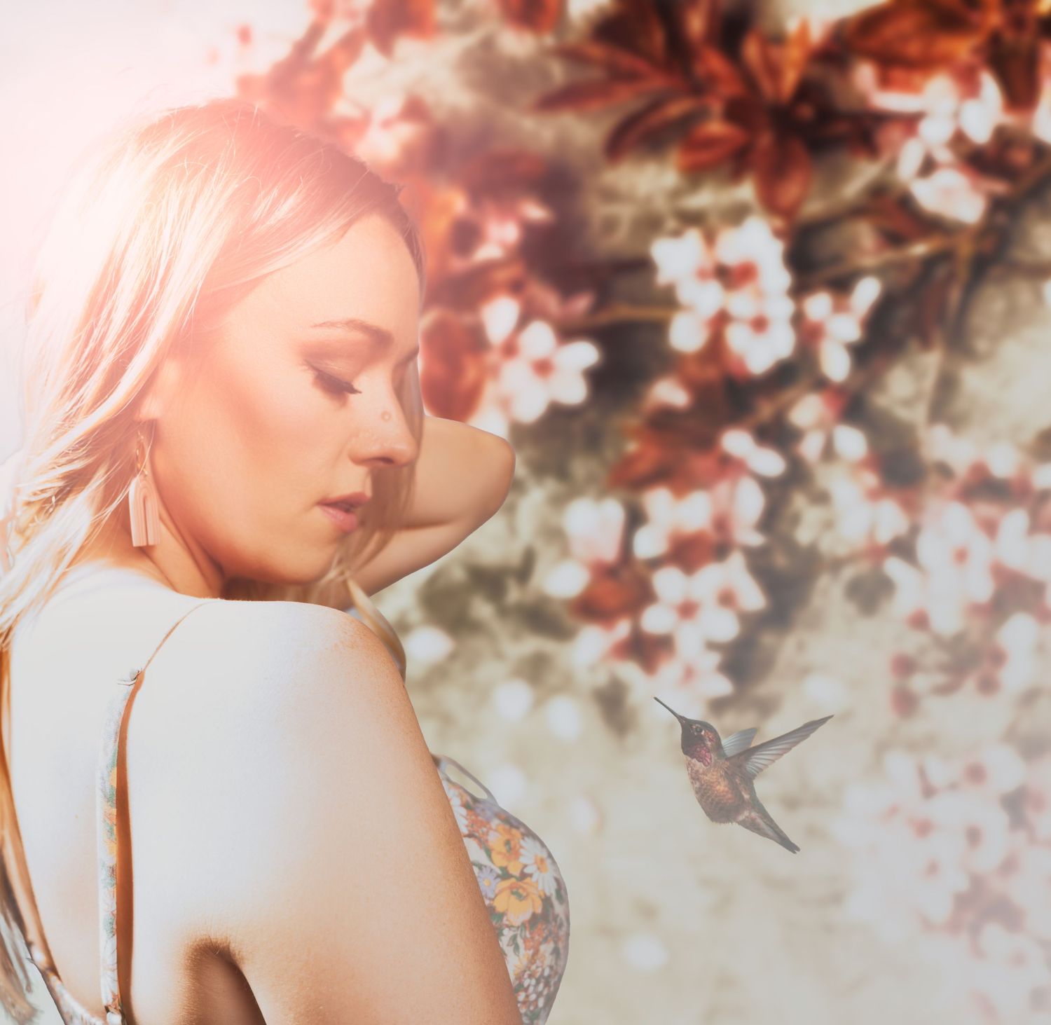 Ethereal spring portrait with cherry blossoms and hummingbird in soft lighting.