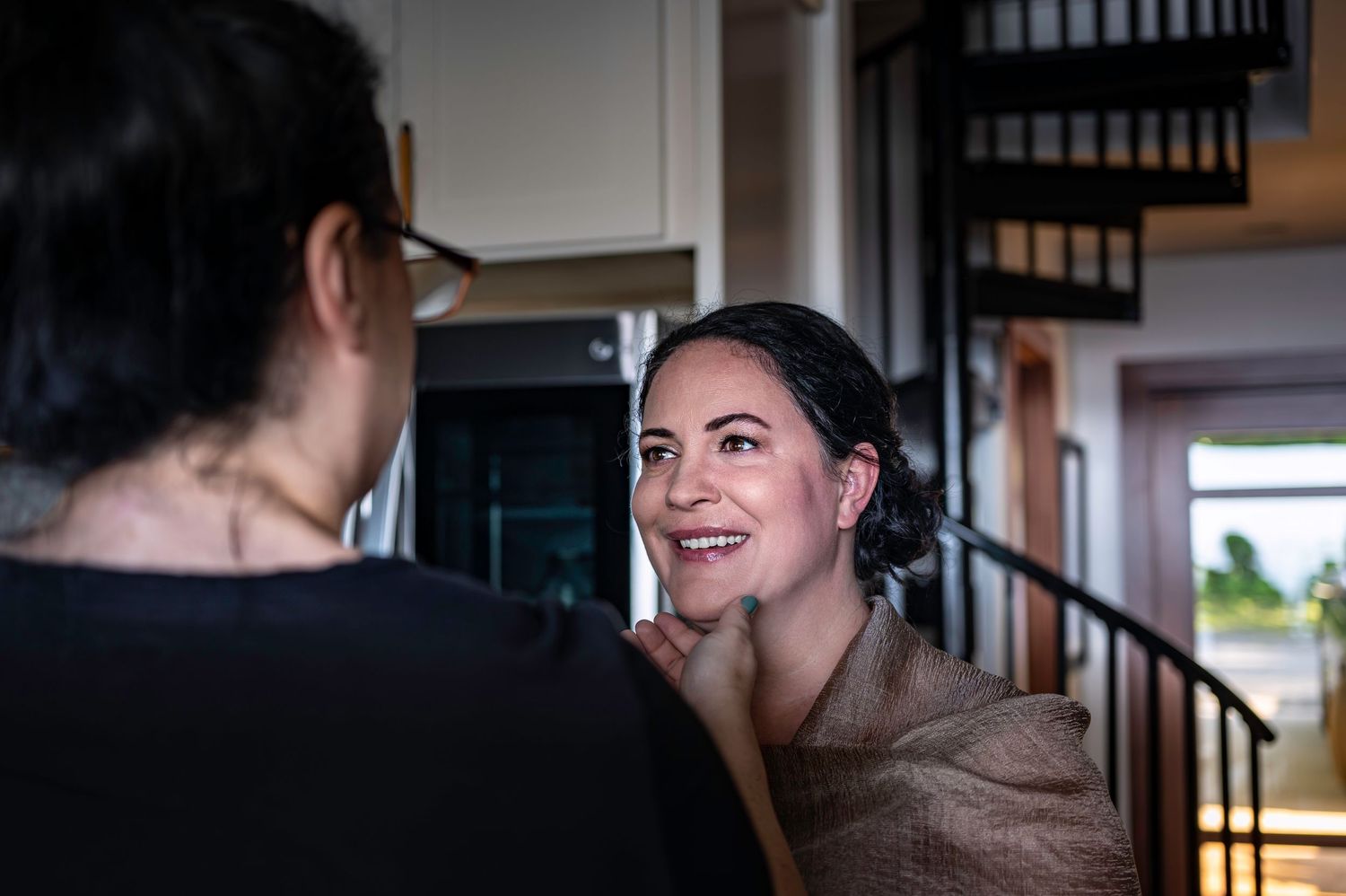 An indoor portrait showing warm interaction between two people in natural lighting.