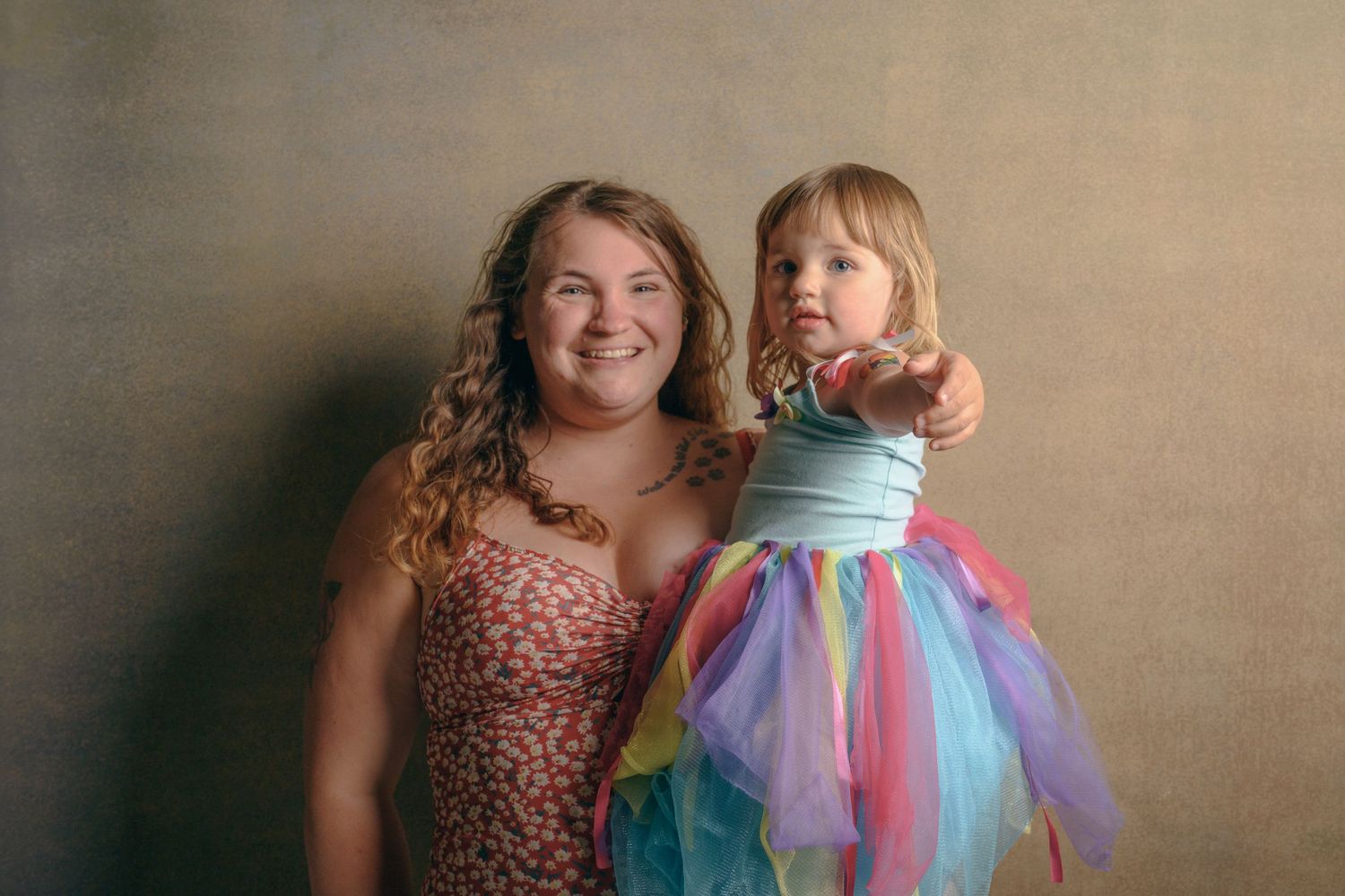 Parent and child in colorful dress pose together for portrait.