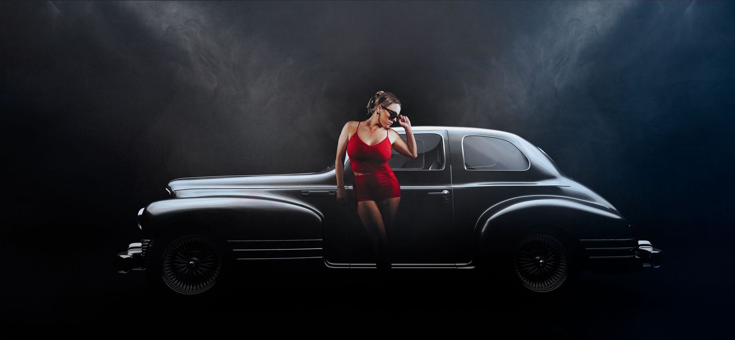 Vintage car photography with dramatic lighting and model in red dress.