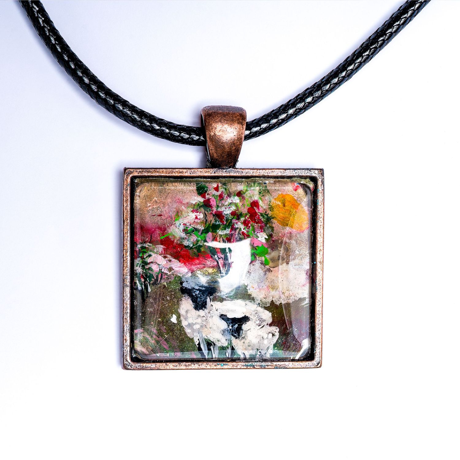 Handcrafted pendant necklace with artistic scene of sheep and florals on black cord.