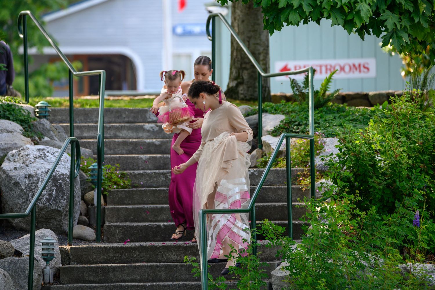 Traditional kimono-clad figures ascending stone steps surrounded by greenery.