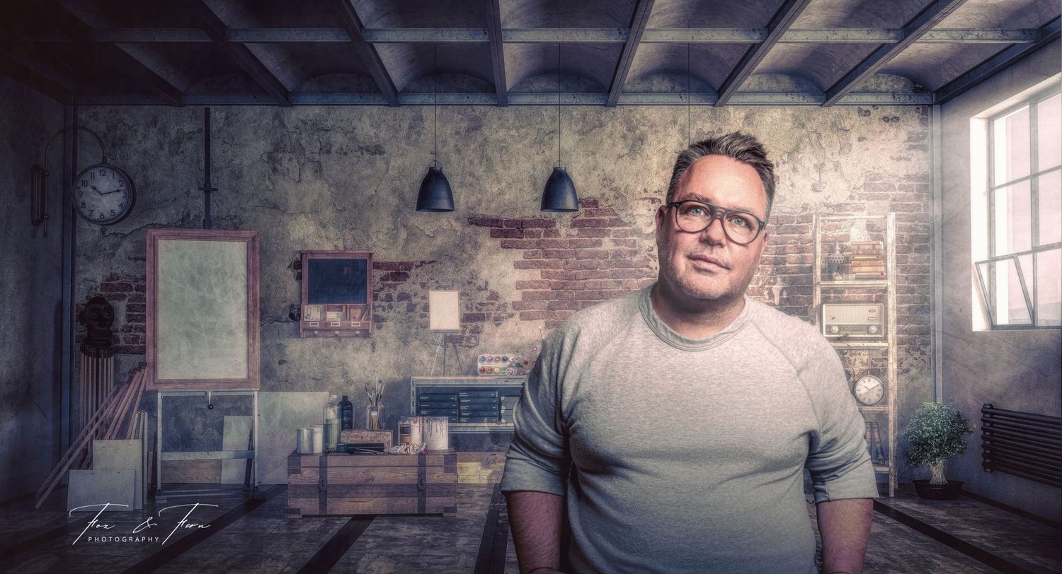 A creative portrait in an industrial loft space with exposed brick walls and hanging pendant lights.
