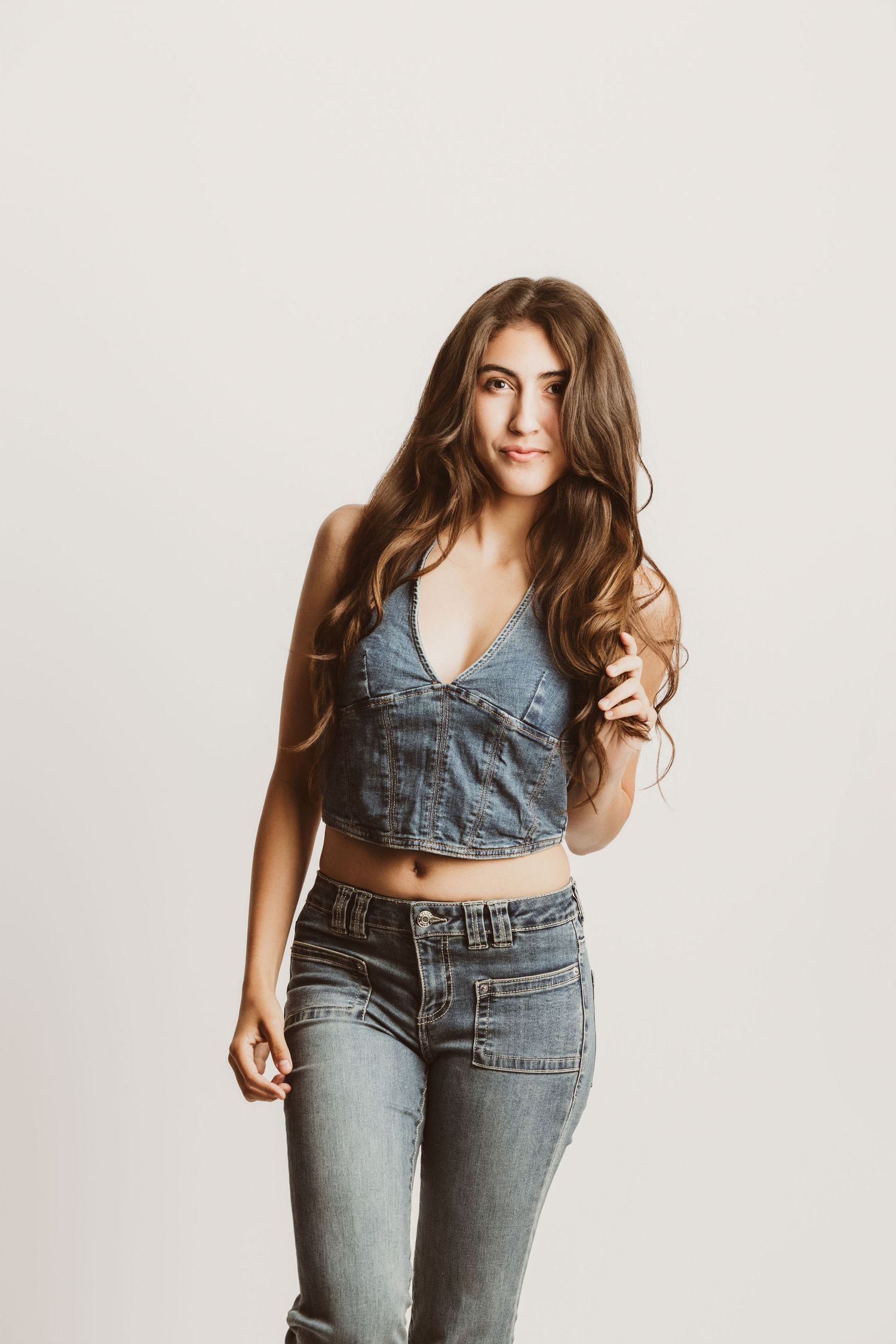 Woman in casual denim outfit posing in four different ways against white backdrop.