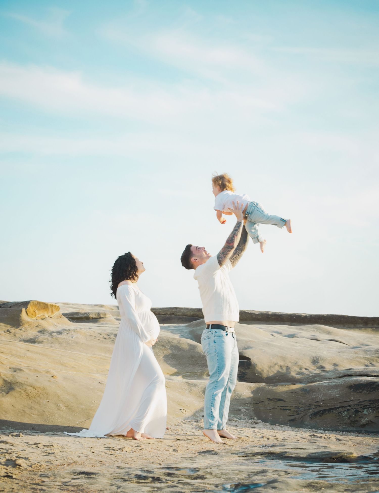 A joyful moment at a sandy beach location as the clear blue sky provides a serene backdrop for a family scene.