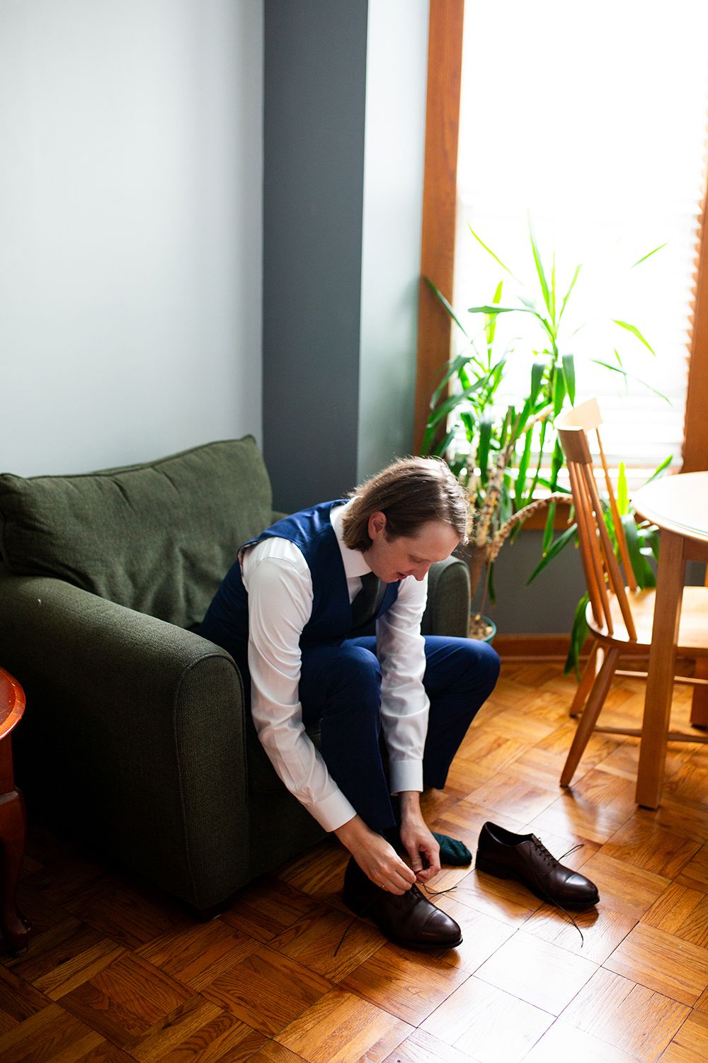 Series showing someone in business attire examining hardwood floorboards in a well-lit room with houseplants.