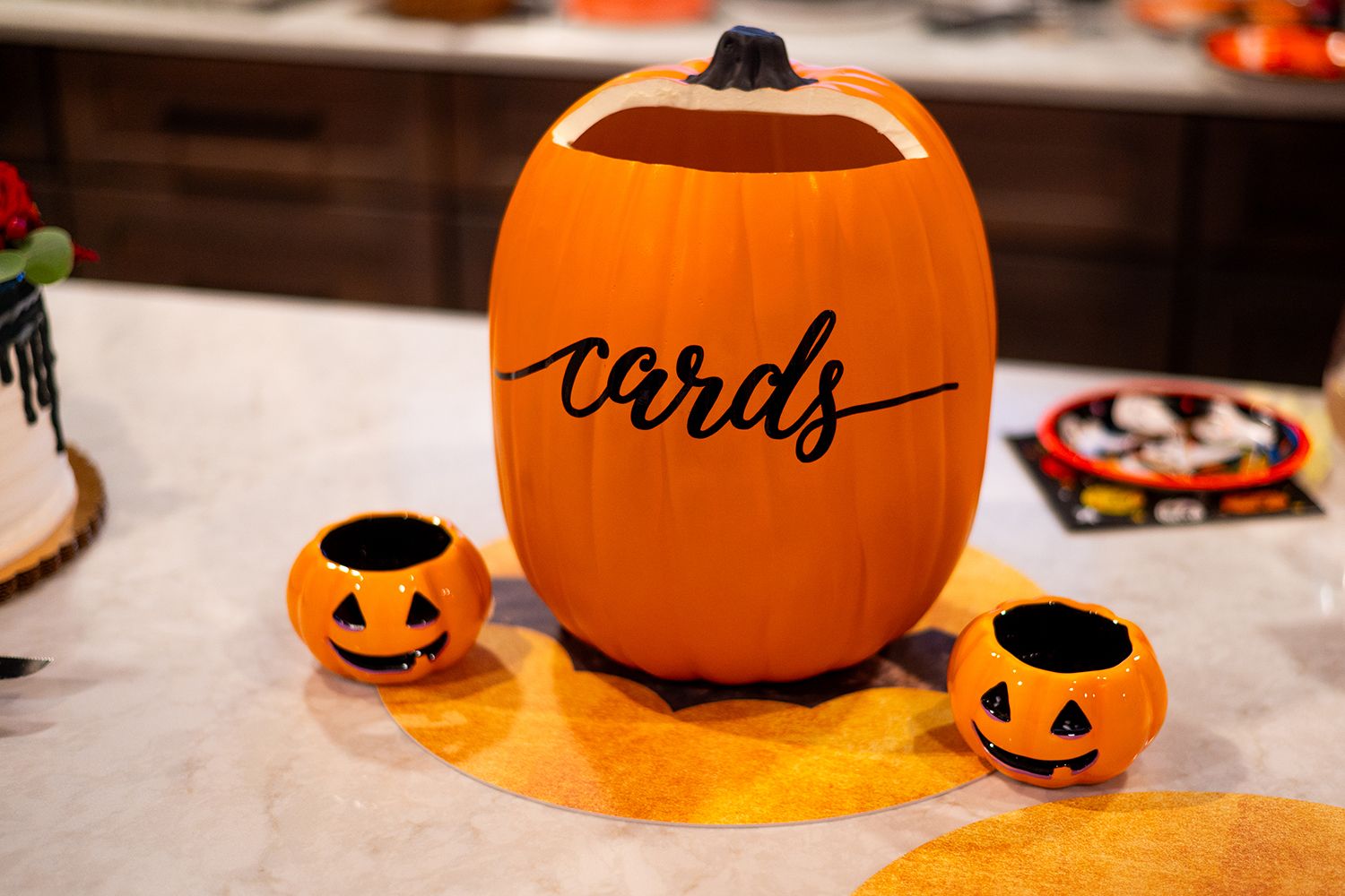 Orange Halloween decorations with a large pumpkin labeled 'cards' and two small smiling jack-o'-lanterns.