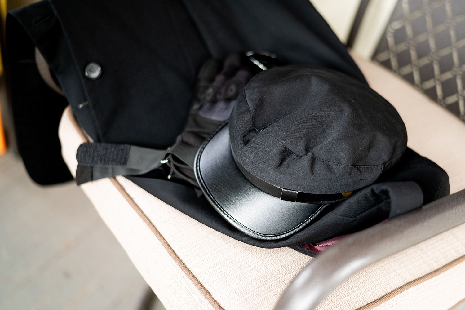 Black modern headphones sit on white surface with geometric shapes behind.