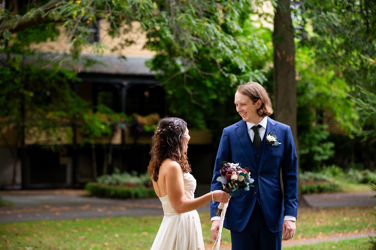 Happy couple shares an intimate moment together in a lush garden setting during their outdoor wedding celebration.