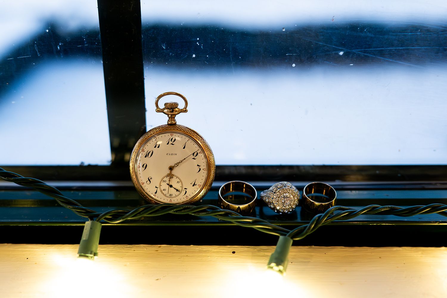 Vintage pocket watches arranged on a dark blue surface with dramatic lighting.