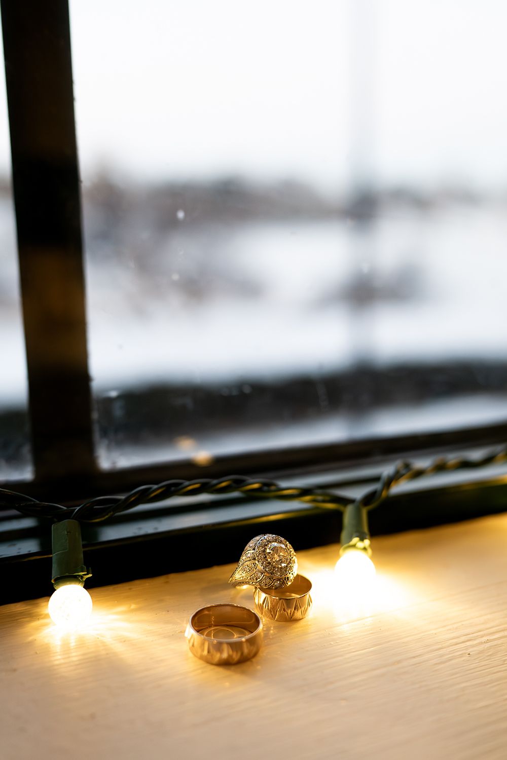 String of warm glowing lights creating a cozy ambiance against a blurred winter window background.