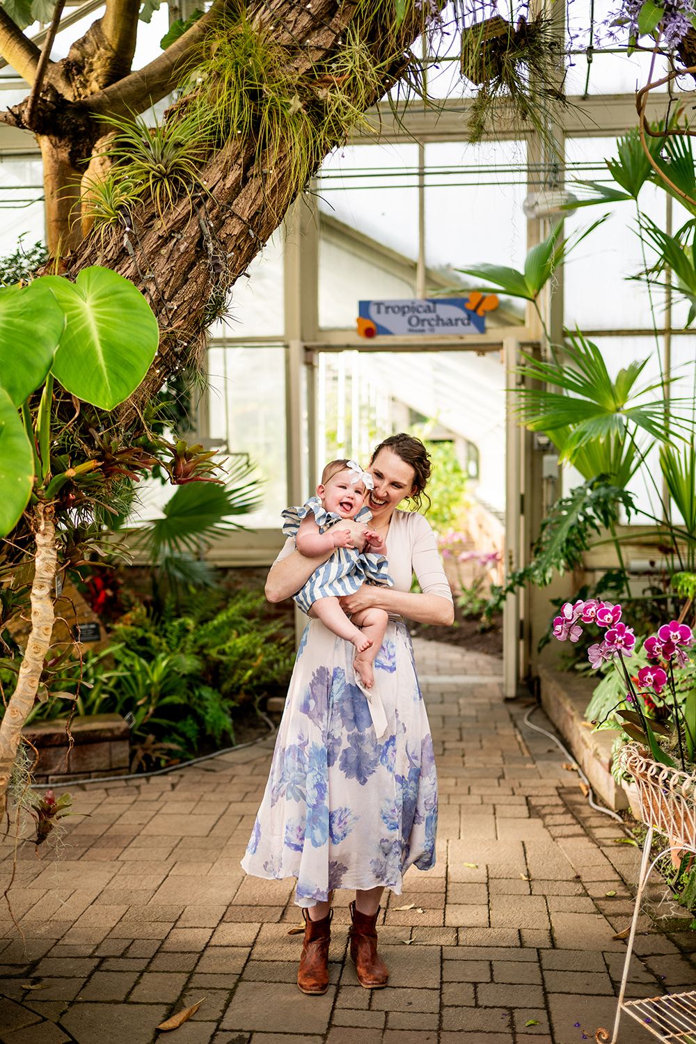 A series of playful dance poses captured in a bright conservatory with tropical plants and stone flooring.