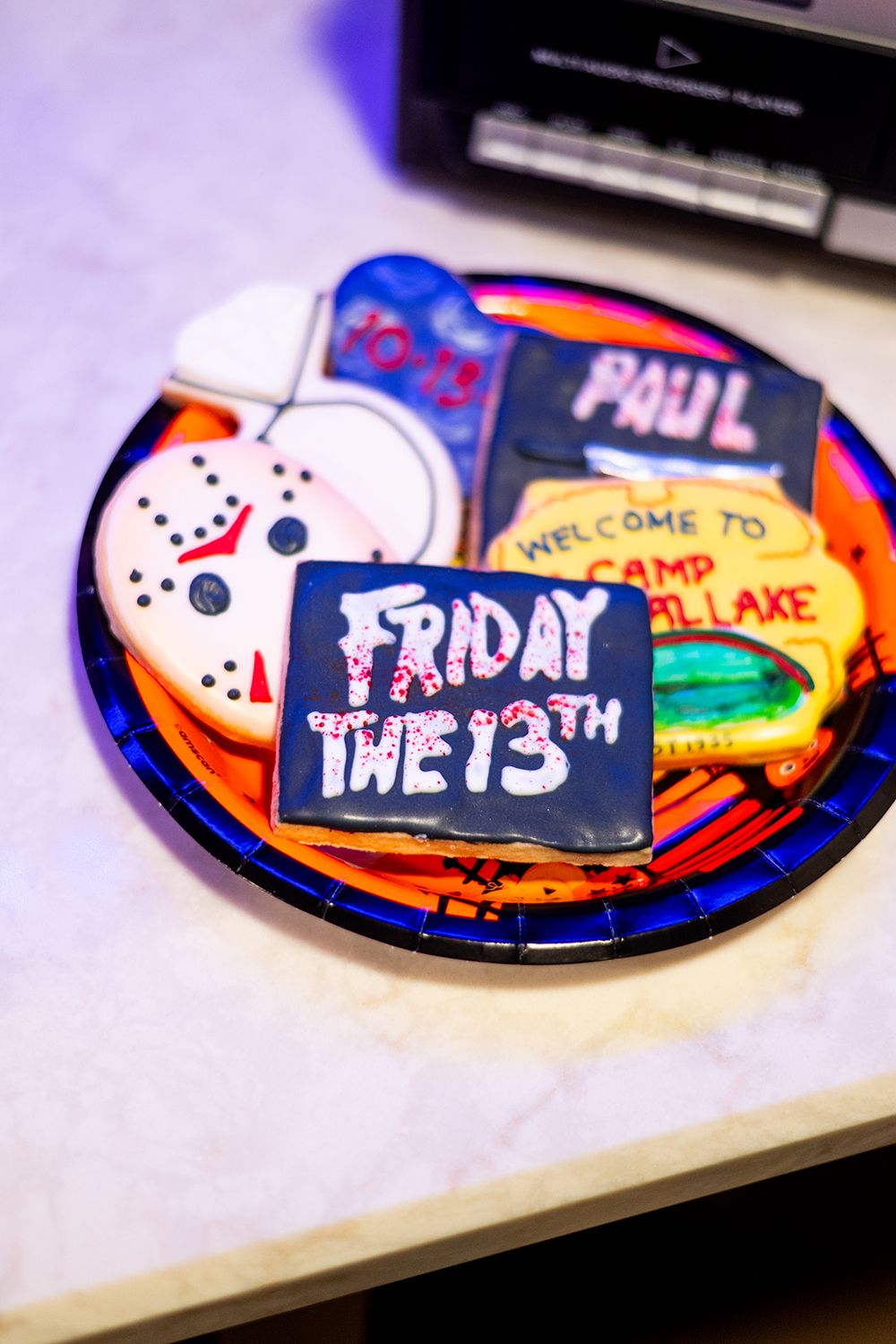 Halloween cookies decorated with Friday the 13th horror movie themes including a hockey mask and Camp Crystal Lake designs.