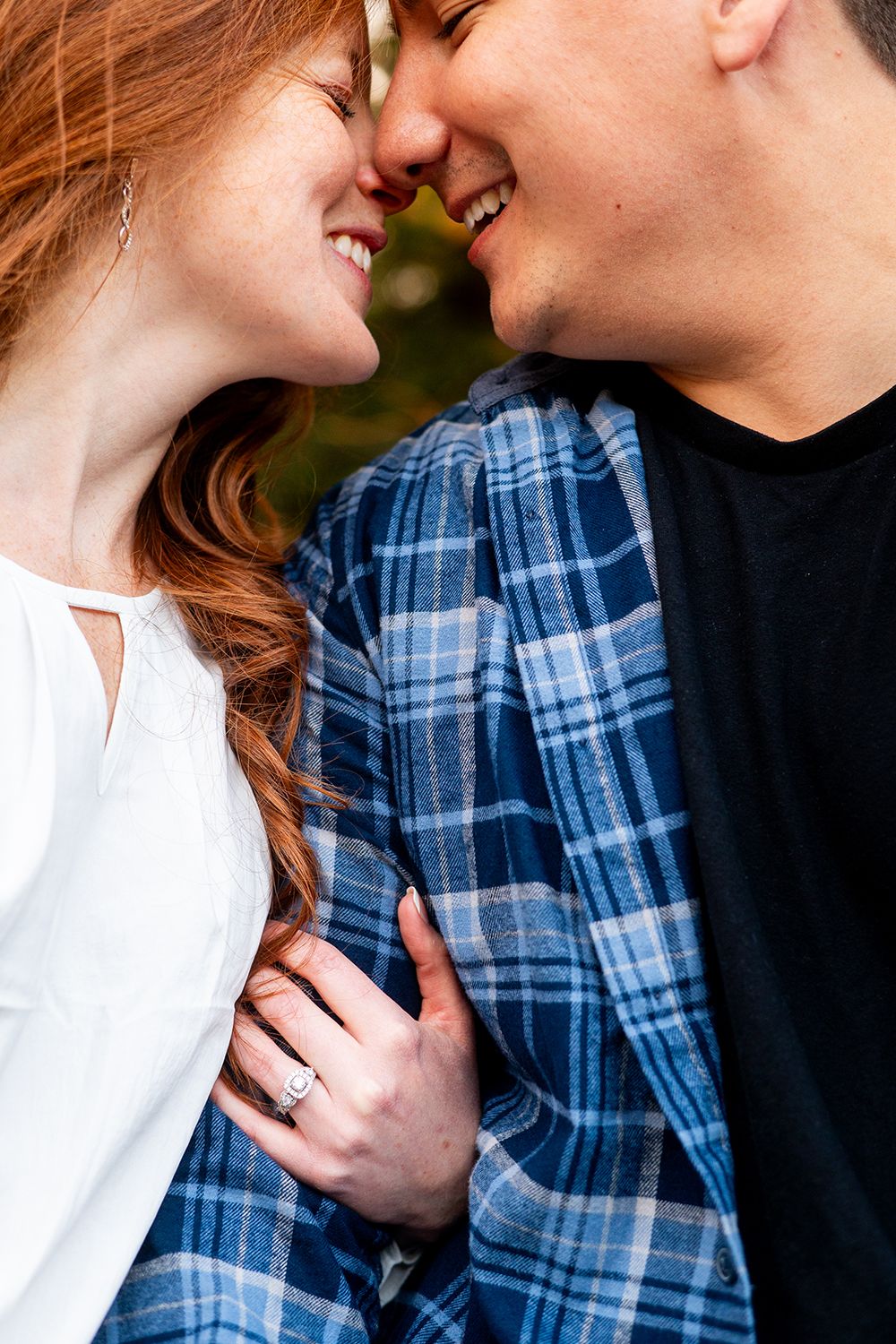 A romantic couple sharing intimate moments while wearing blue plaid shirt and white top in soft lighting.