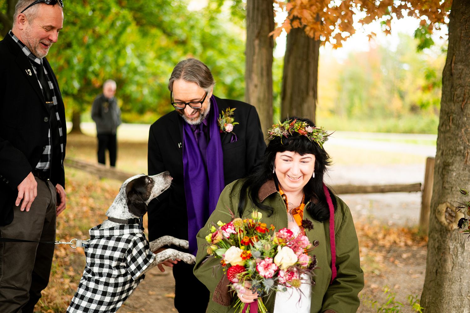 A joyful gathering in an autumn park with people laughing together as beautiful fall foliage surrounds them.