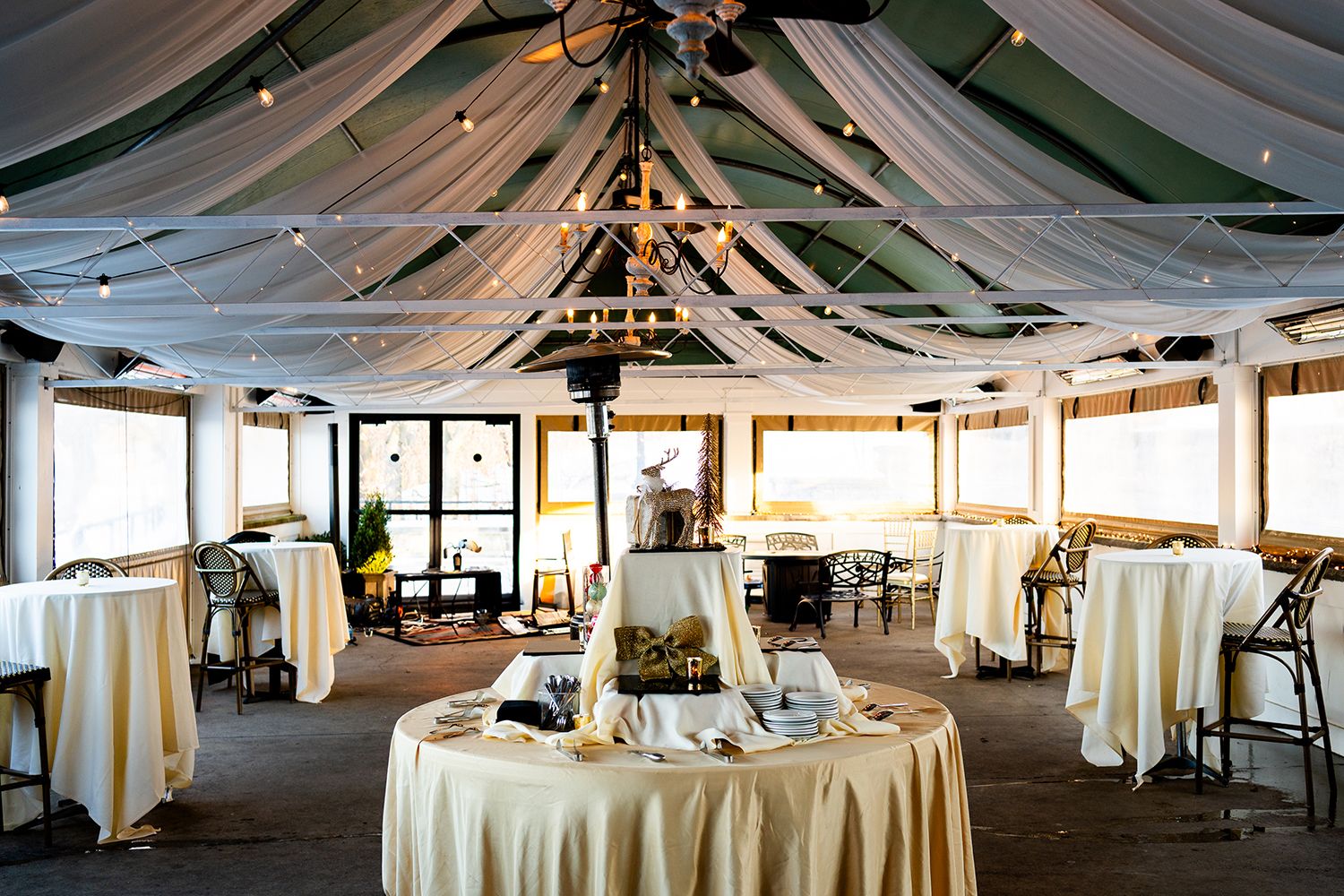 An elegant white draped fabric ceiling decoration in a spacious wedding reception venue.