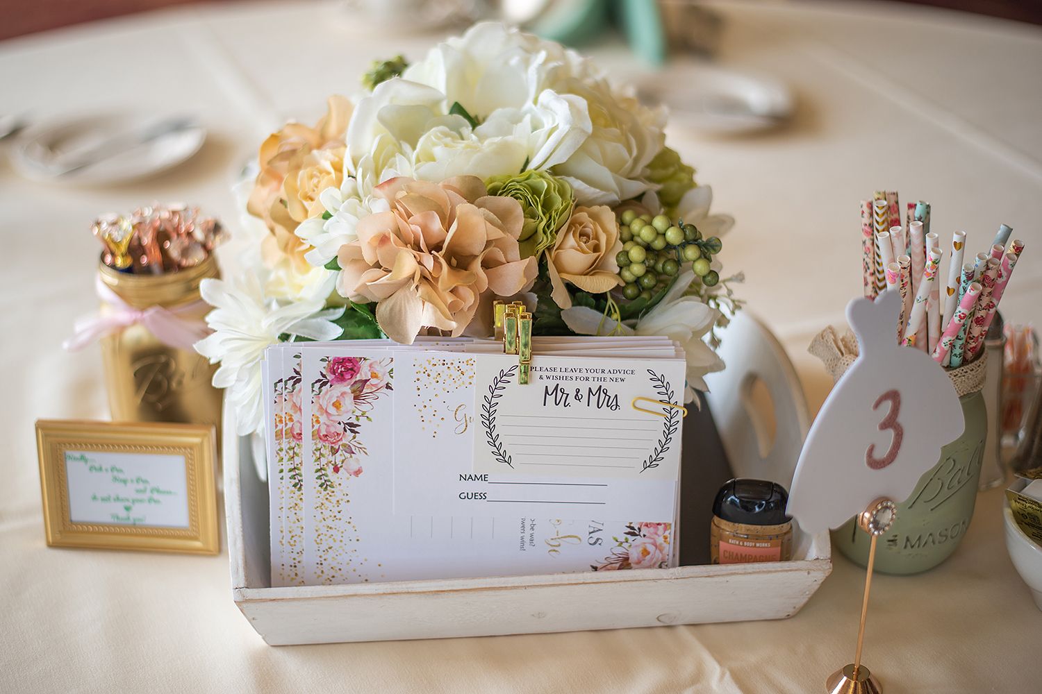 Elegant wedding table decor featuring Mason jars and delicate floral arrangements with pastel accents.