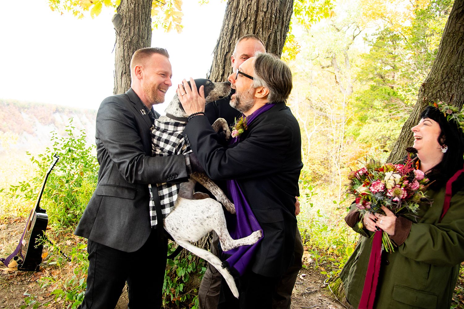A couple shares joyful moments together during an autumn outdoor photoshoot surrounded by trees and fall foliage.