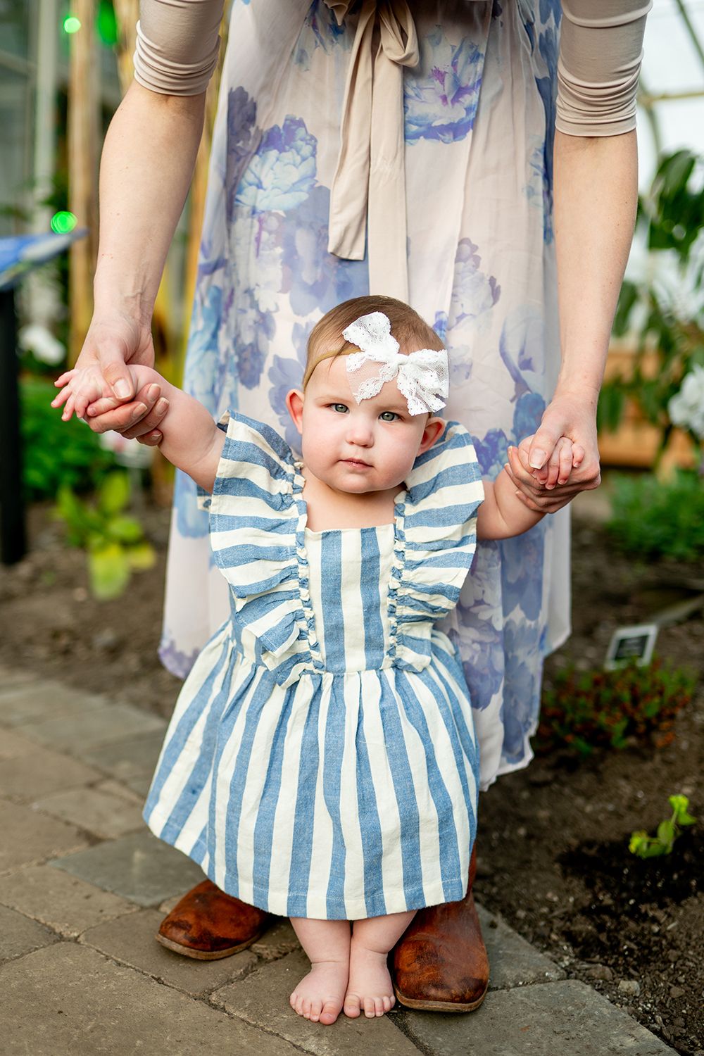 A series of photos showing a baby's striped blue and white dress and bare feet against a floral backdrop.
