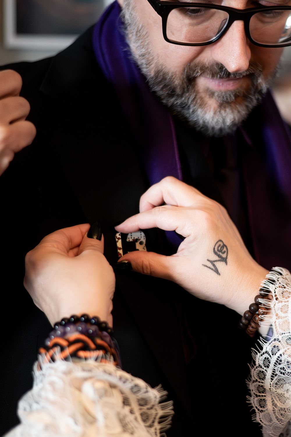 Close-up series showing hands adjusting decorative white lace and black beaded jewelry accessories.