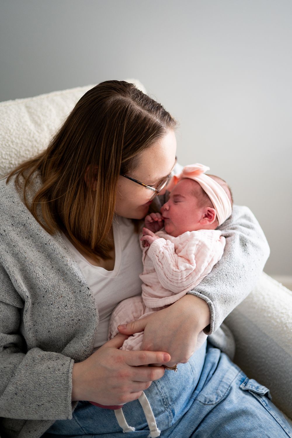 Intimate newborn photography session captures parents bonding with their baby against a minimalist white background.