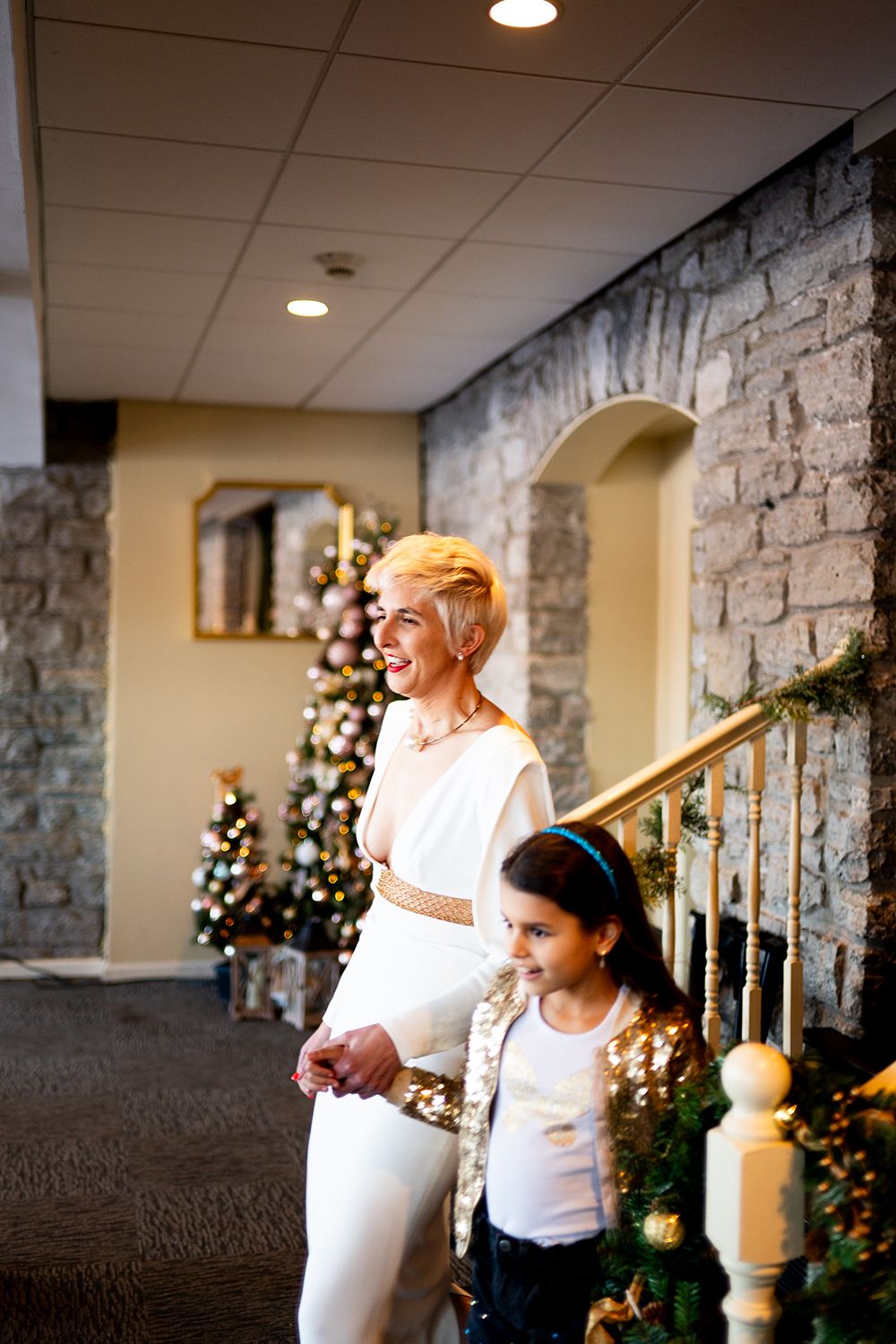 A sequence of connected photos shows two people sharing a joyful moment amid Christmas decorations and stone walls.