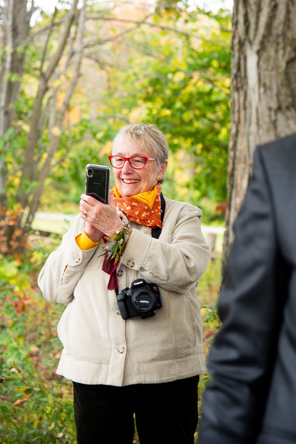 A candid three-panel sequence showing joyful laughter while holding a camera during an outdoor autumn photoshoot.