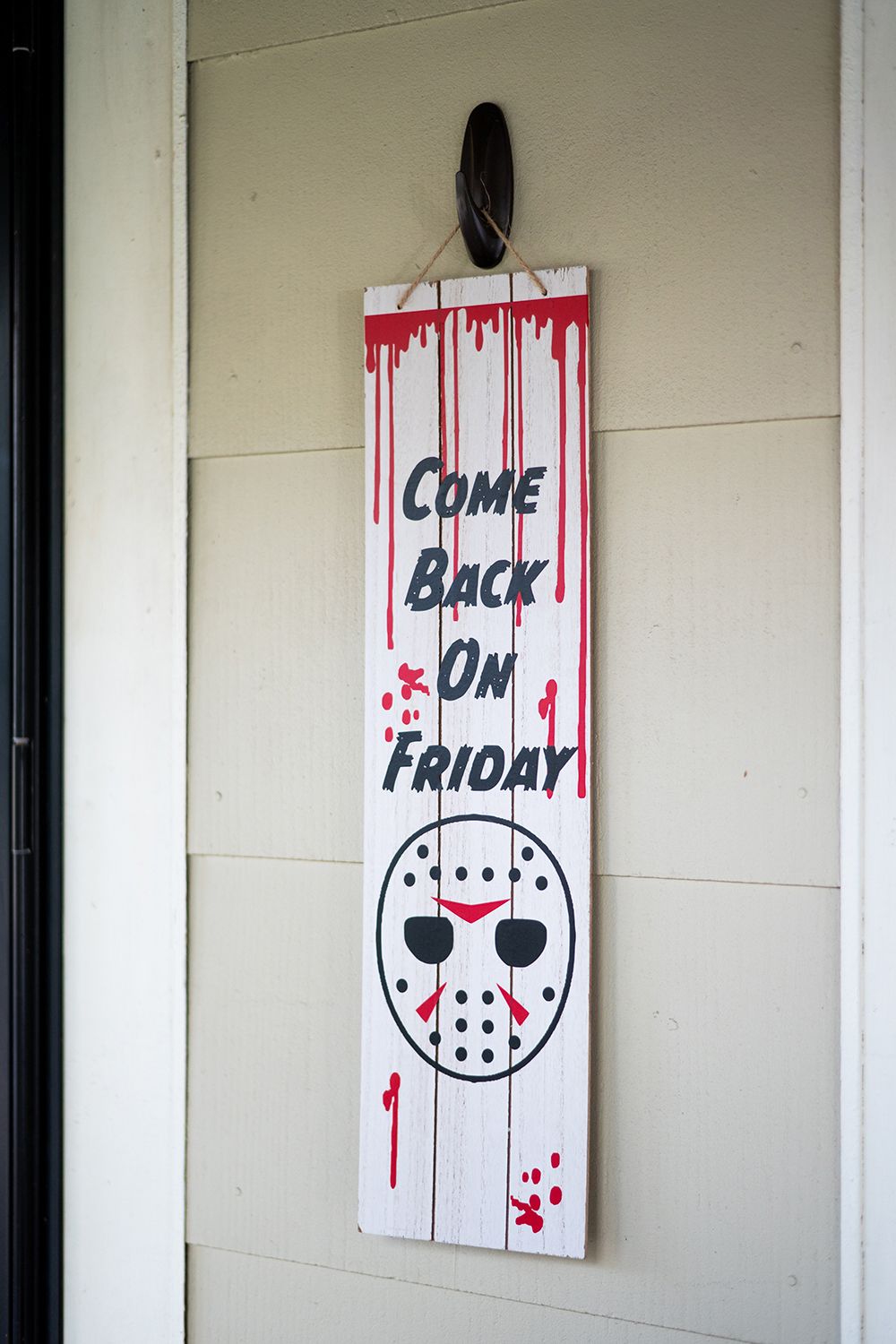 Three white wooden panels featuring blood-spattered hockey mask designs with text inspired by Friday the 13th movie theme.