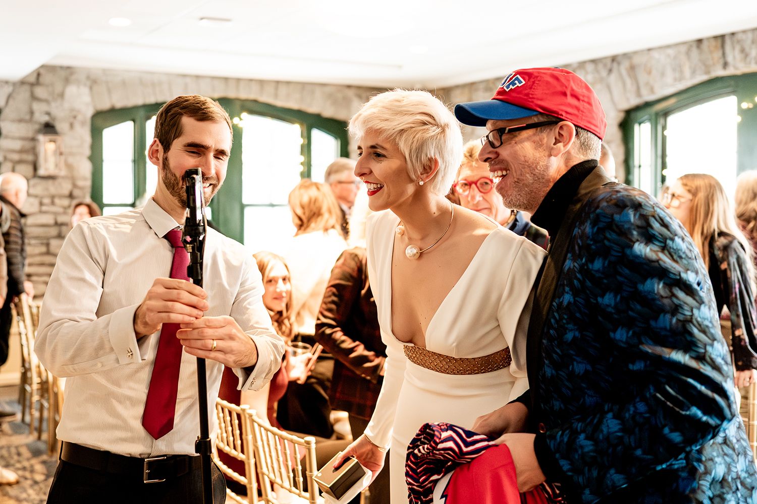 Celebratory gathering in a rustic venue with stone walls and guests seated at dining tables during a festive event.