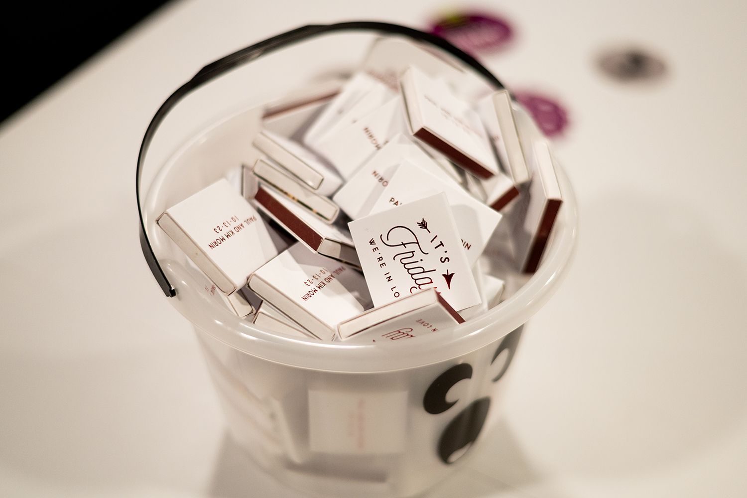 Pink and white paper packets for Open Equal or some other item sit in a clear plastic container.