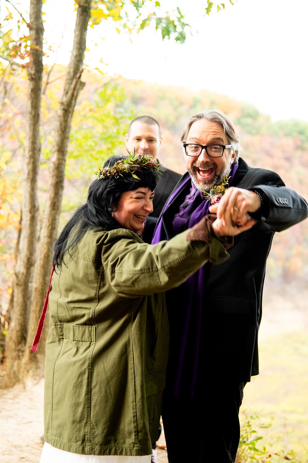 A joyful moment captured during a casual outdoor wedding ceremony in autumn.