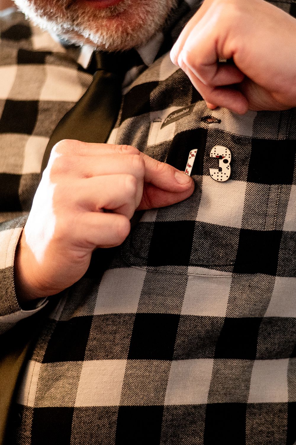 Hands adjusting a black and white checkered plaid cloth on a surface.
